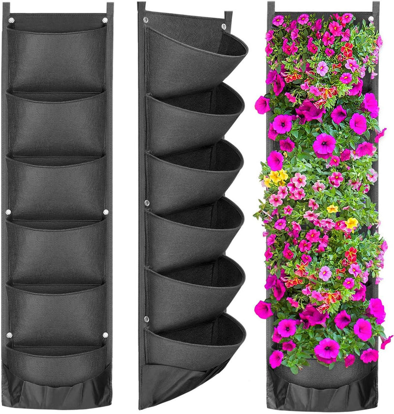 Vertical wall garden with black fabric pots holding flowers
